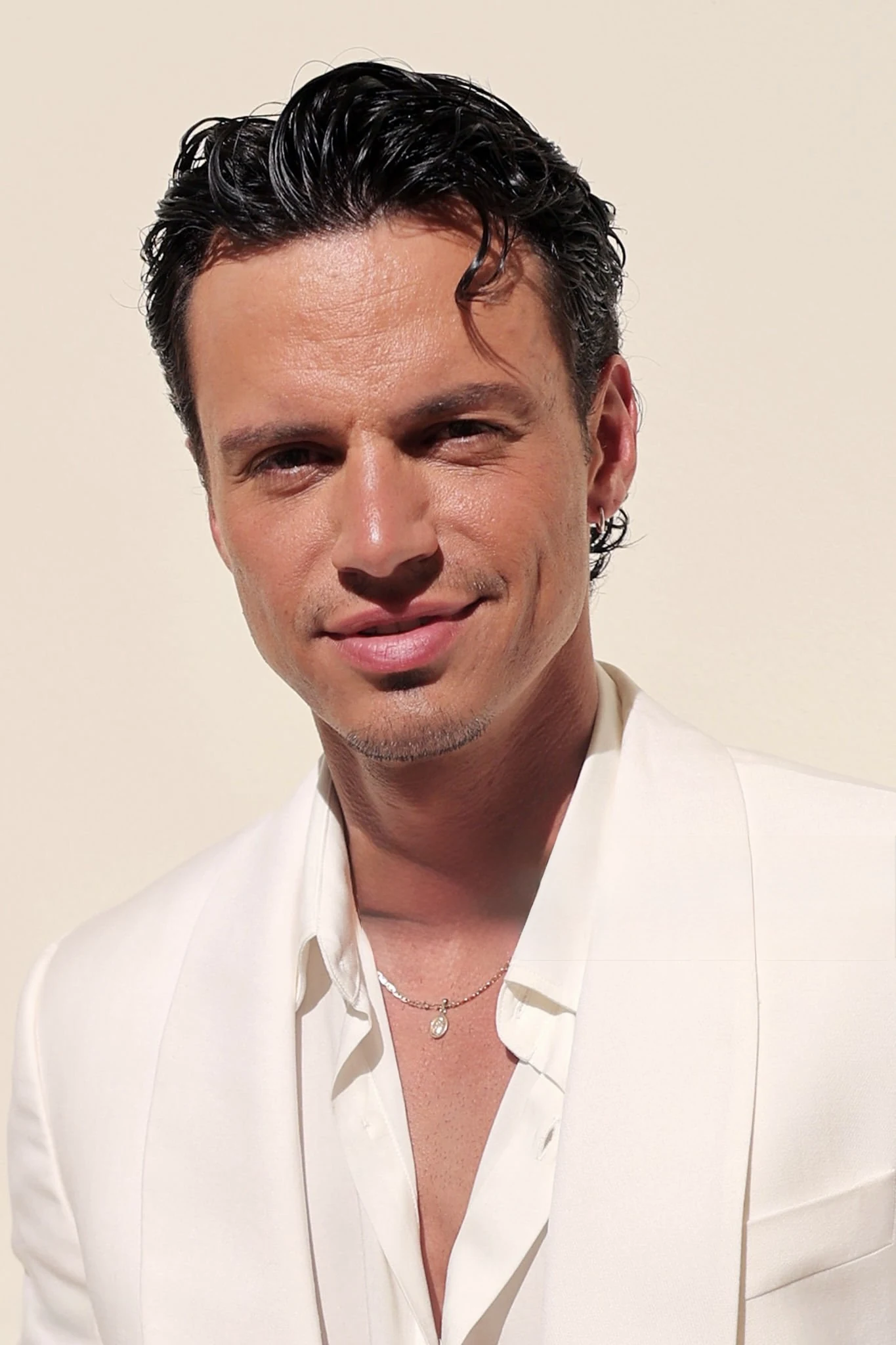 Kevin Dias with styled dark hair wearing a cream suit